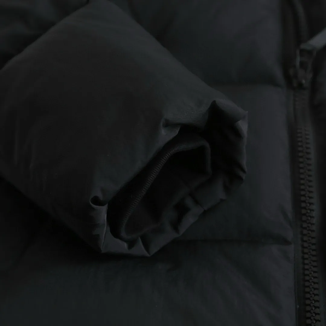 P1010 [Exclusive supply] Canada Goose Black Label Badge Hooded Down Jacket (Black) The high-quality filling is made of 90 national standard high-quality white duck down, selected high-loft velvet, weighing 240g, light and warm, with excellent temperature locking performance and good resilience. The fabric is woven with 400T high-count yarn. After special water-repellent treatment, the surface forms a lotus leaf effect - raindrops will slide down like beads, and snow particles will fall off when touched. The tear resistance reaches 200N (approximately 20kg load-bearing), the light gray matte texture breaks the stereotype of "outdoor clothing = hardcore", and the soft luster presents a high-end matte effect under urban neon lights, seamlessly switching scenes from ski resorts to CBD office buildings. The ribbon is woven with polyester as the base, and the brand letters are decorated on the ribbon through high-precision computer embroidery. The edges of the pattern are clear, the stitches are fine and even, and multiple layers of embroidery thread are stacked to enhance the three-dimensional effect. Precision thread reinforcement prevents linting and ensures the fluffy and resilient elasticity lasts as new. The embedded cuffs are three-dimensionally woven to form a "wavy" elastic structure, which forms natural folds when fitting the wrist, increasing the contact area with the skin, thus improving the windproof effect. At the same time, micro-velvet treatment is added to the inside of the cuffs, which feels like a second layer of skin and avoids friction on the skin from metal zippers or hard fabrics. Size:S-M-L-XL